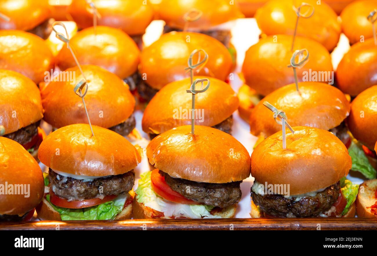 Mini hamburger individuali serviti come tartine in una festa Foto Stock