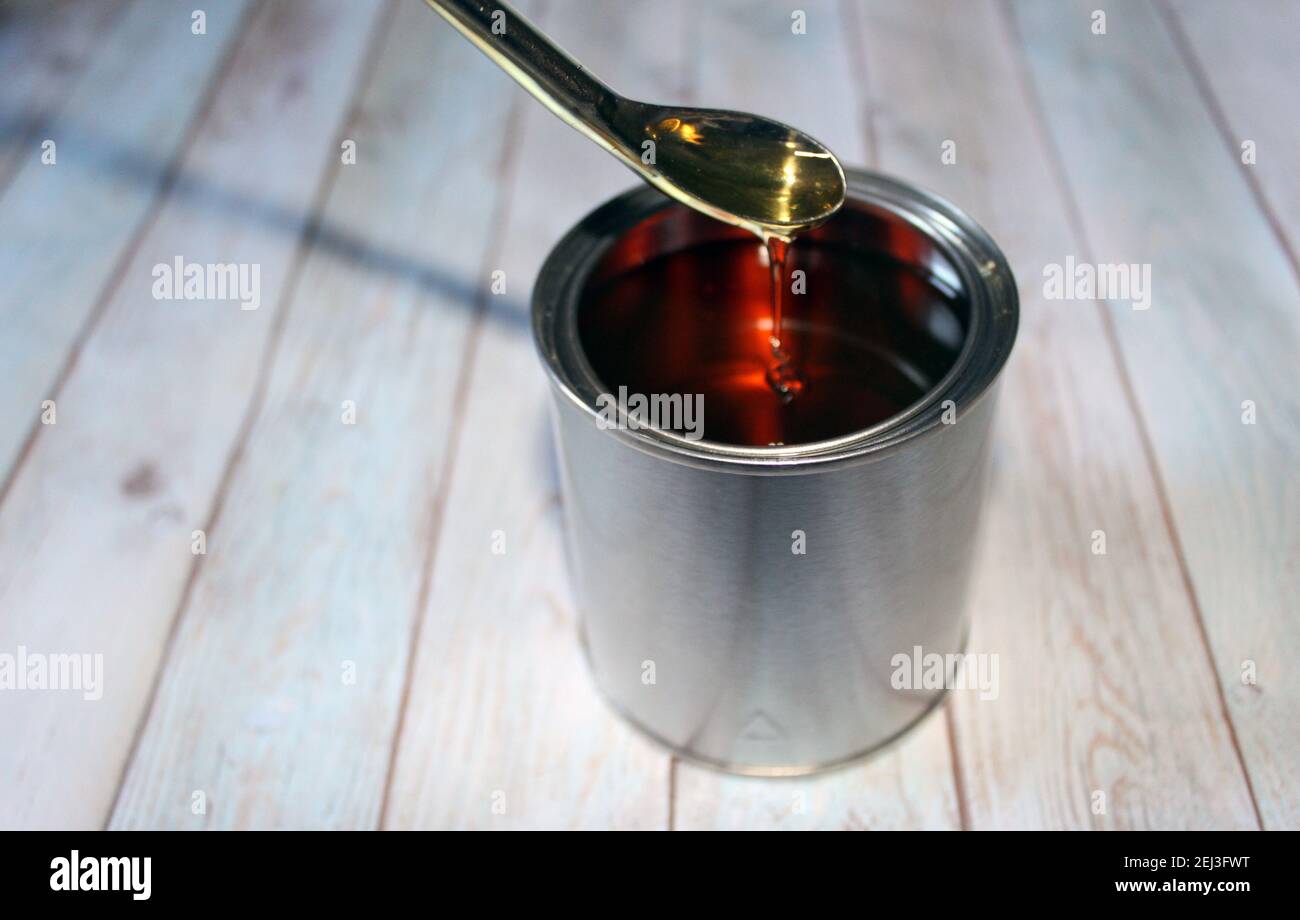 Tecnico che pesa resina alchidica per una vernice in una lattina su un  equilibrio da spatola su sfondo di legno Foto stock - Alamy