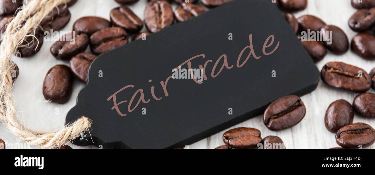 Kaffeebohnen auf Holz mit Label Fair Trade Foto Stock