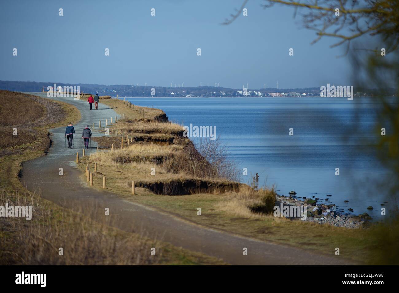 21 febbraio 2021, Schleswig-Holstein, Lübeck: Escursionisti di un giorno fare una passeggiata lungo la costa al Brodtener Steilufer nella baia di Lübeck a temperature primaverili. Foto: Gregor Fischer/dpa Foto Stock