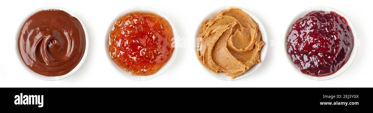 Set di varie salse dolci - crema di cioccolato, marmellata d'arancia, burro di arachidi e marmellata di frutti di bosco misti in un piatto rotondo isolato su sfondo bianco, vista dall'alto Foto Stock