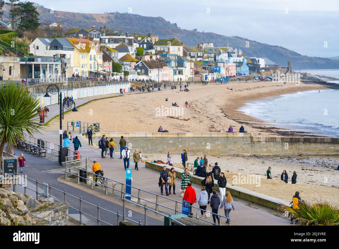 Lyme Regis, Dorset, Regno Unito. 21 Feb 2021. Regno Unito Meteo: Le persone godono di un caldo e soleggiato Domenica pomeriggio sulla spiaggia presso la località balneare di Lyme Regis, come il recente bagnato e buio tempo scompare portando più caldo, condizioni di sole la prossima settimana. Credit: Celia McMahon/Alamy Live News Foto Stock
