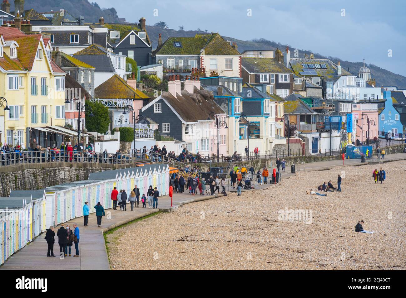 Lyme Regis, Dorset, Regno Unito. 21 Feb 2021. Regno Unito Meteo: Le persone godono di un caldo e soleggiato Domenica pomeriggio sulla spiaggia presso la località balneare di Lyme Regis, come il recente bagnato e buio tempo scompare portando più caldo, condizioni di sole la prossima settimana. Credit: Celia McMahon/Alamy Live News Foto Stock