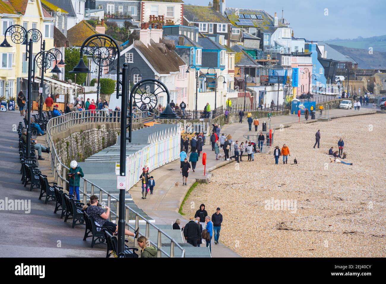 Lyme Regis, Dorset, Regno Unito. 21 Feb 2021. Regno Unito Meteo: Le persone godono di un caldo e soleggiato Domenica pomeriggio sulla spiaggia presso la località balneare di Lyme Regis, come il recente bagnato e buio tempo scompare portando più caldo, condizioni di sole la prossima settimana. Credit: Celia McMahon/Alamy Live News Foto Stock