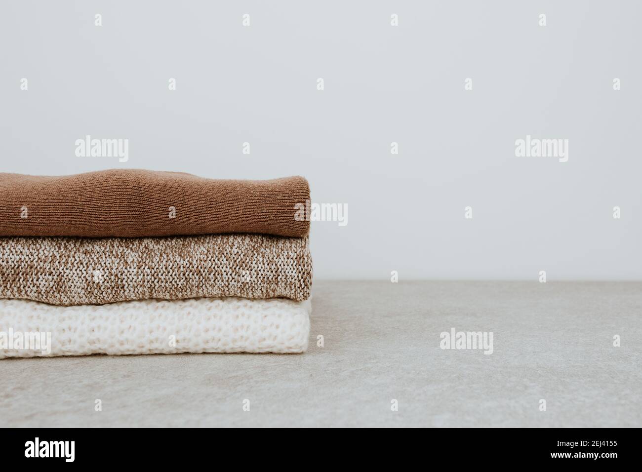 Composizione moda donna. Caldo inverno donna lana maglia pullover, pullover stack su sfondo bianco. Concetto di abbigliamento moderno per la rivista. Foto Stock