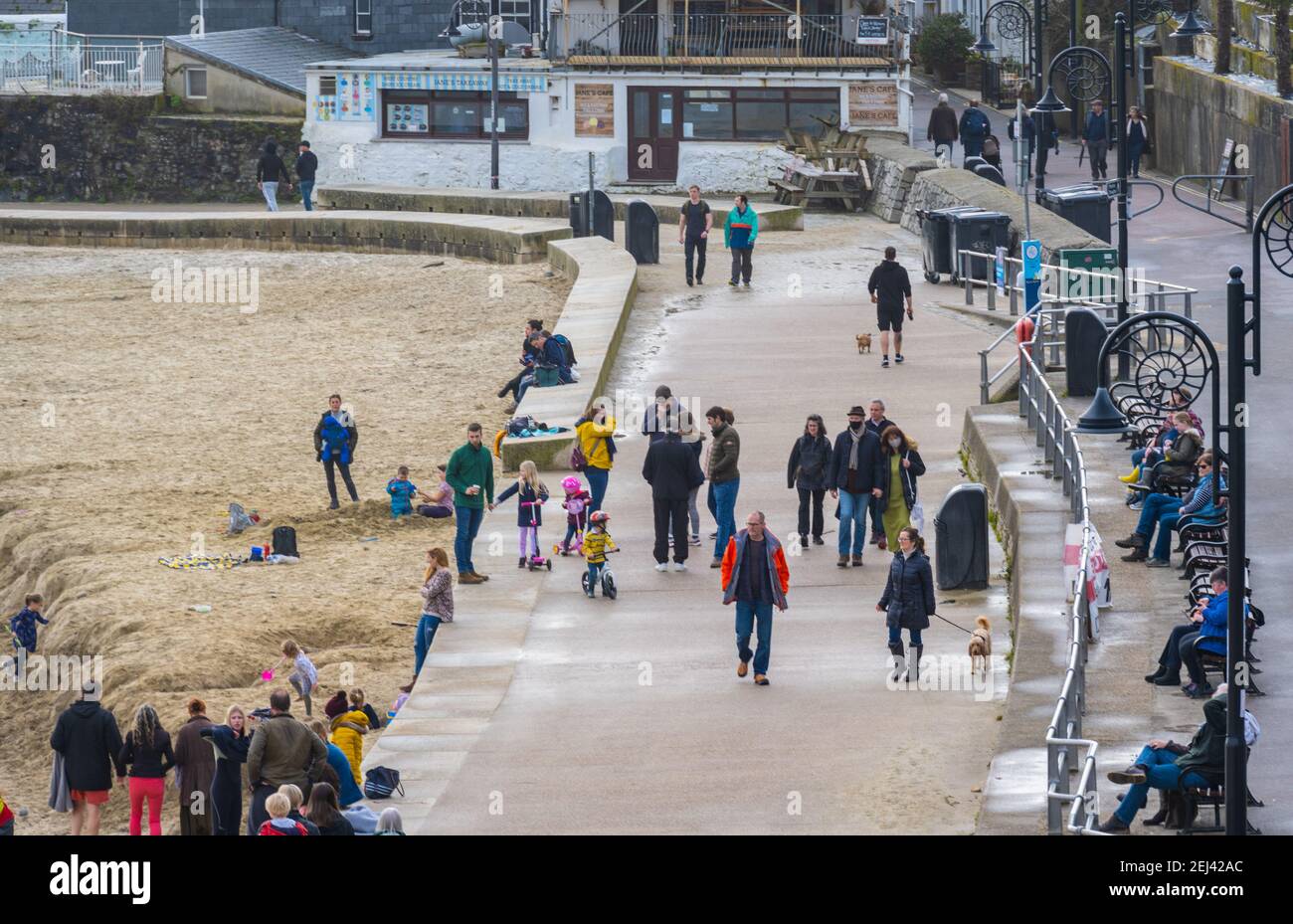 Lyme Regis, Dorset, Regno Unito. 21 Feb 2021. Regno Unito Meteo: Le persone godono di un caldo e soleggiato Domenica pomeriggio sulla spiaggia presso la località balneare di Lyme Regis, come il recente bagnato e buio tempo scompare portando più caldo, condizioni di sole la prossima settimana. Credit: Celia McMahon/Alamy Live News Foto Stock