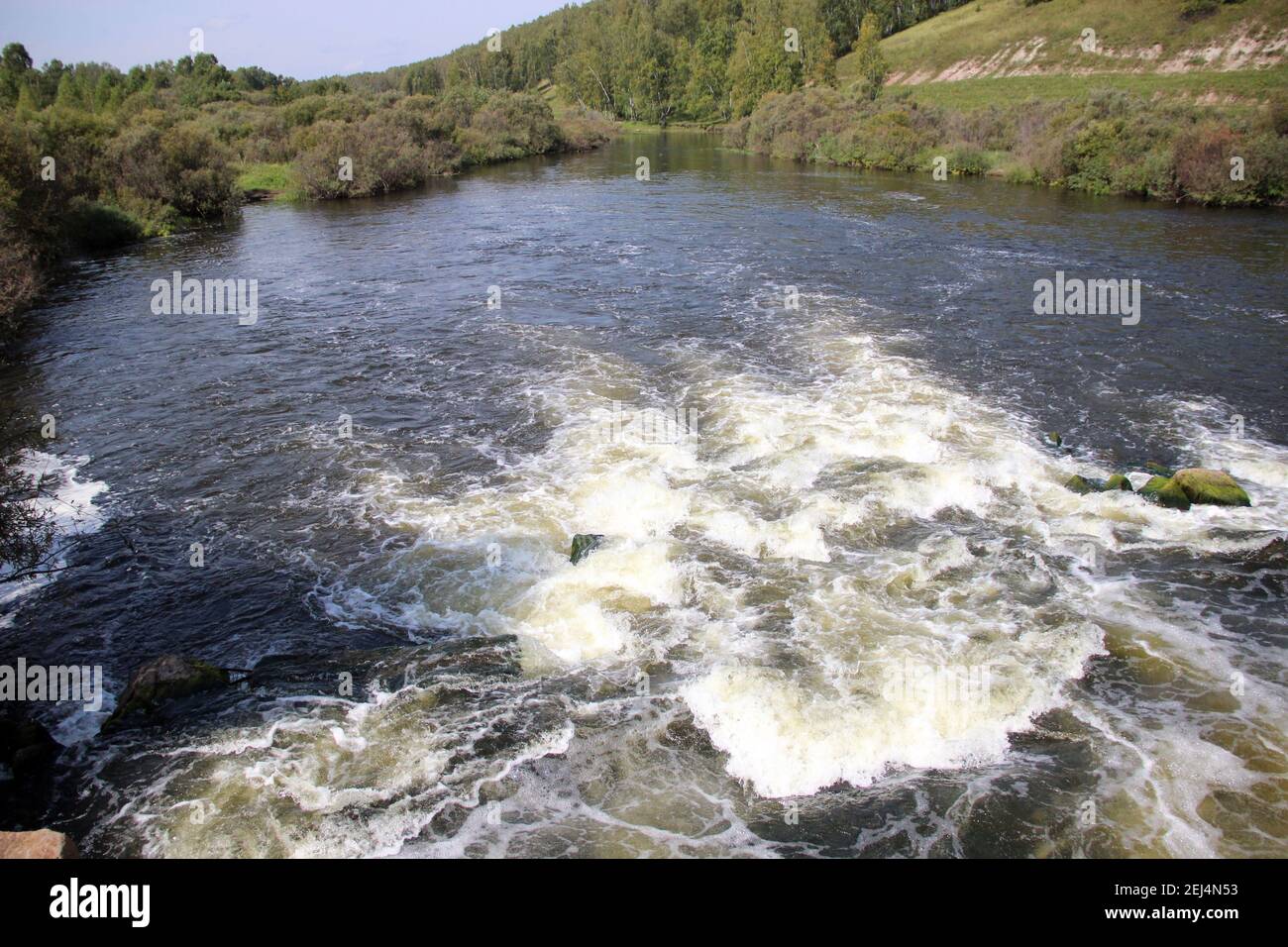Il fiume di montagna scorre sopra le rocce che bolle e schiumano. Foto Stock