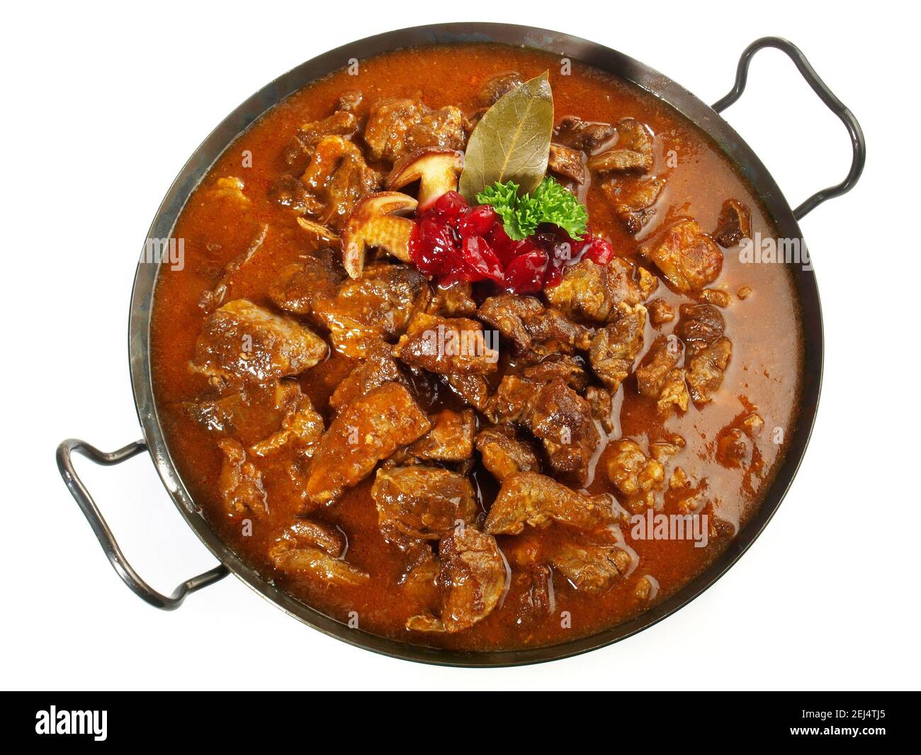 Selvaggina ragù di carne in una padella con mirtilli rossi isolati Su sfondo bianco Foto Stock Selvaggina ragù di carne in una padella con mirtilli rossi isolati Su sfondo bianco Foto Stock