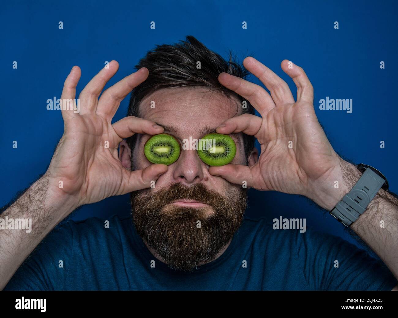 L'uomo si pone sul viso con kiwi e limoni Foto Stock