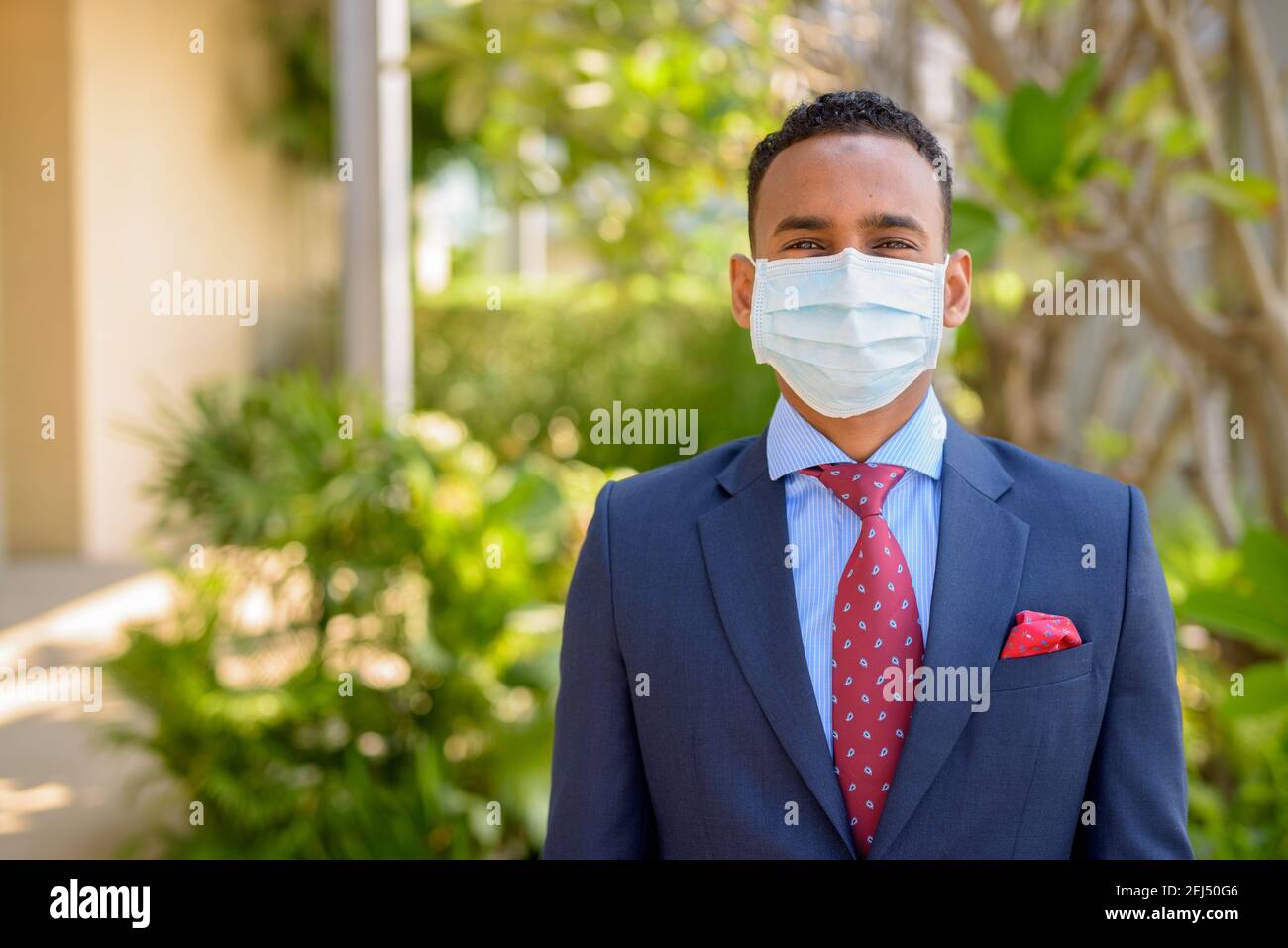 Uomo d'affari africano con maschera medica chirurgica per la protezione all'aperto Foto Stock