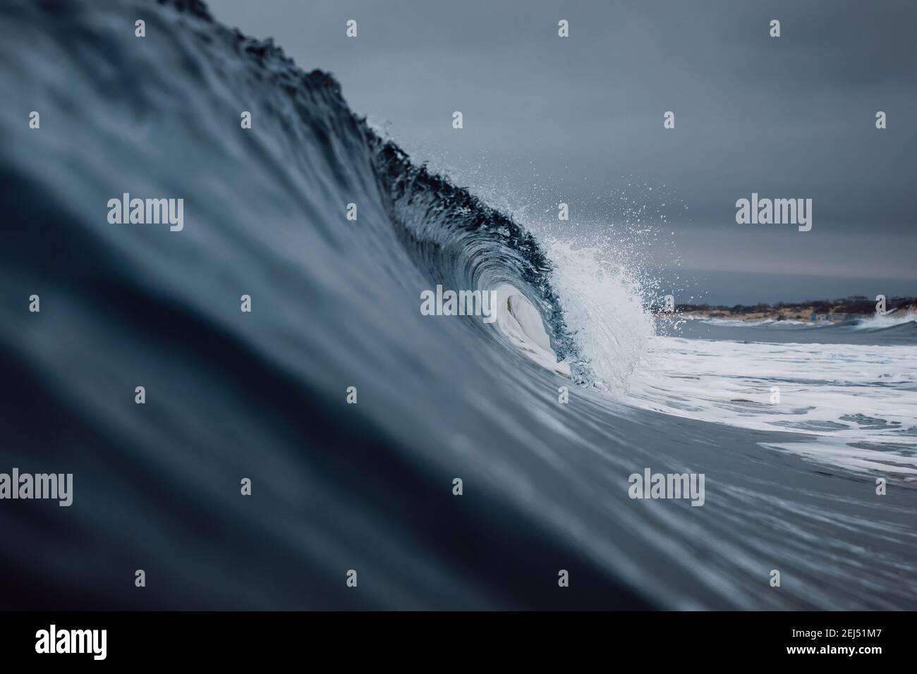 Onde oceaniche perfette con acqua blu cielo scuro nuvoloso. Foto Stock