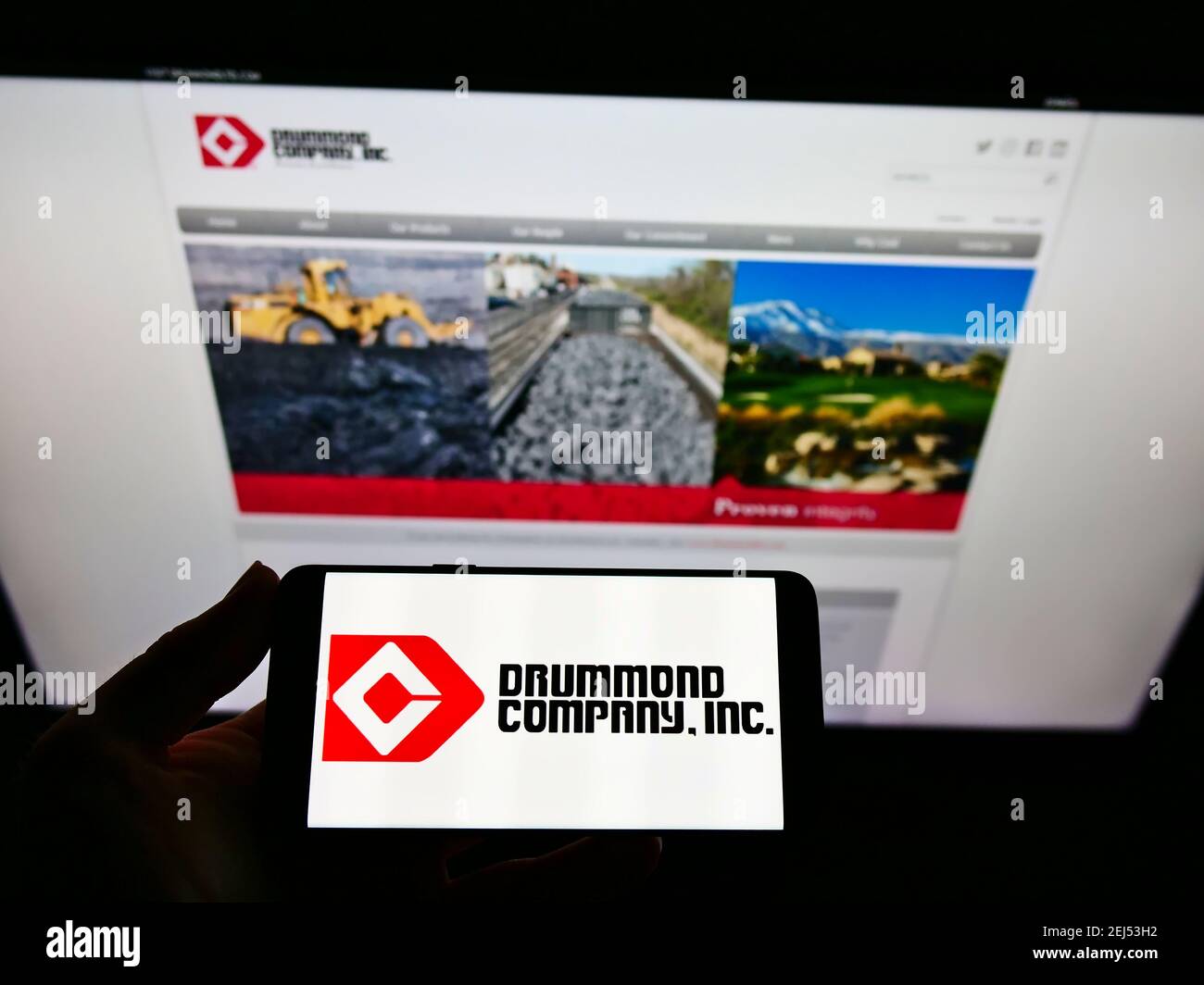 Persona che tiene lo smartphone con il logo del business minerario americano Drummond Company Inc. Sullo schermo di fronte al sito Web. Mettere a fuoco il display del telefono. Foto Stock