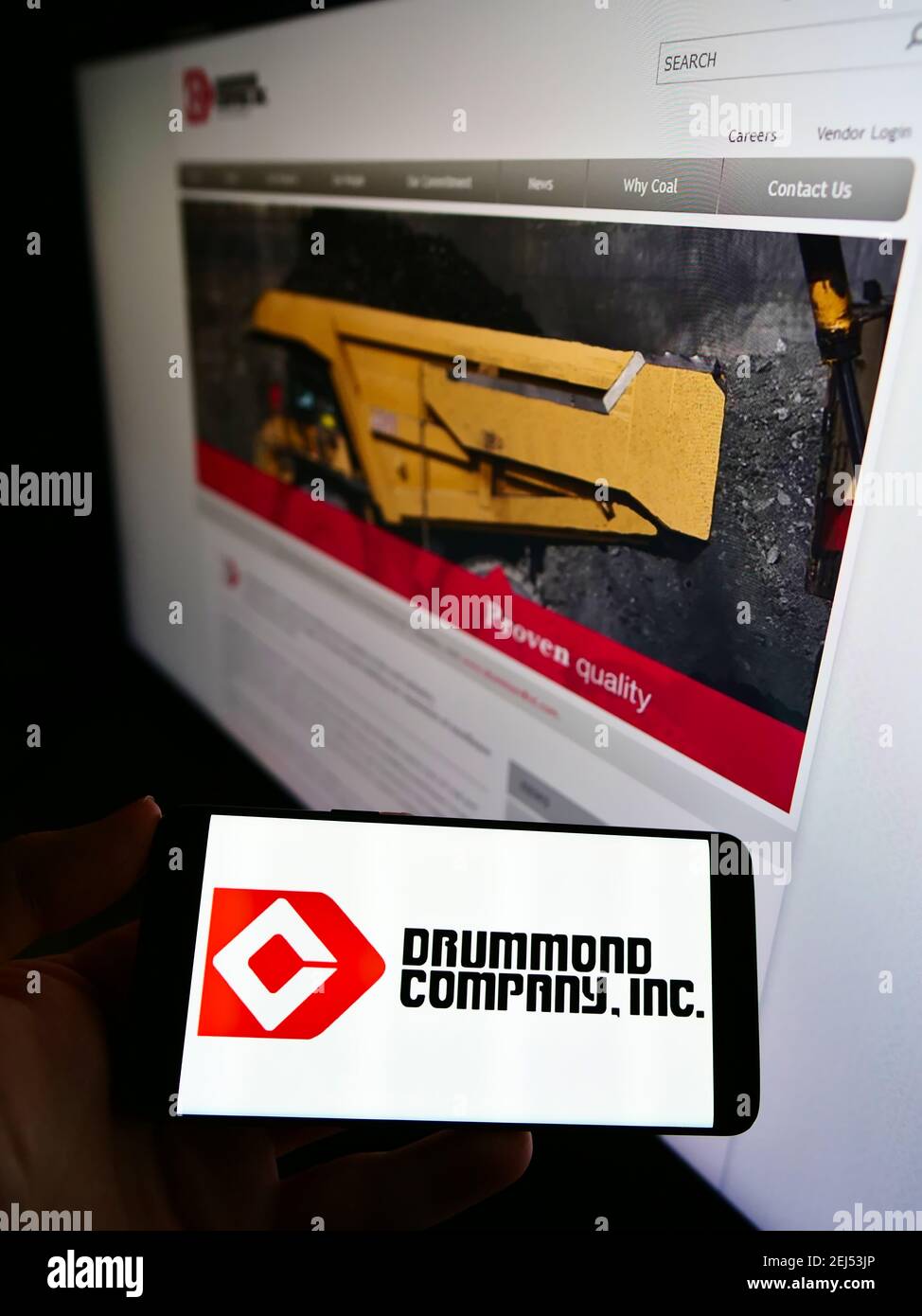 Persona che tiene il telefono mobile con il logo del commercio minerario americano Drummond Company Inc. Sullo schermo davanti alla pagina web. Focus sul display del cellulare. Foto Stock