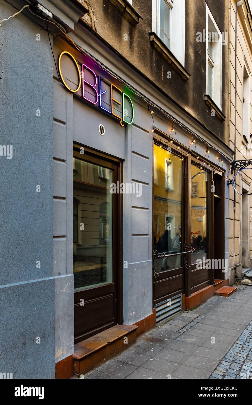 Poznan, Polonia - Febbraio 15 2020 facciata del pub vicino alla piazza del mercato con colorato cartello al neon 'Obłed' ('Madness') Foto Stock