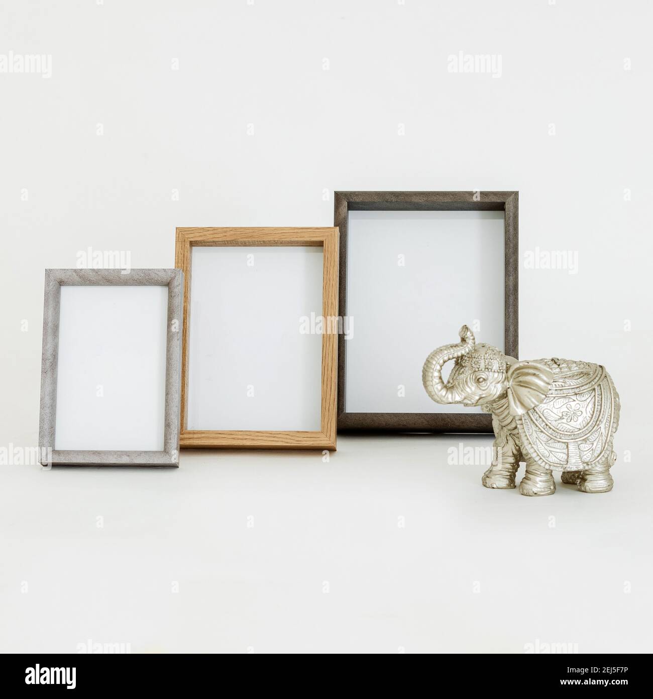 Una closeup di tre mockups di cornice dorata vuoti in differenti dimensioni accanto a una scultura di elefante Foto Stock