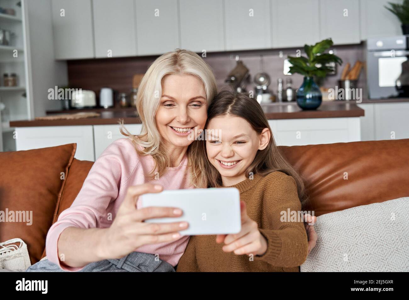 Felice adolescente figlia e madre di mezza età divertirsi utilizzando smartphone. Foto Stock