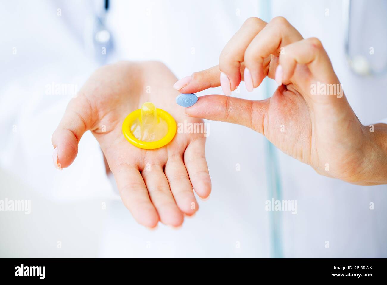 Primo piano di medico femminile che tiene la pillola per la salute degli uomini Foto Stock