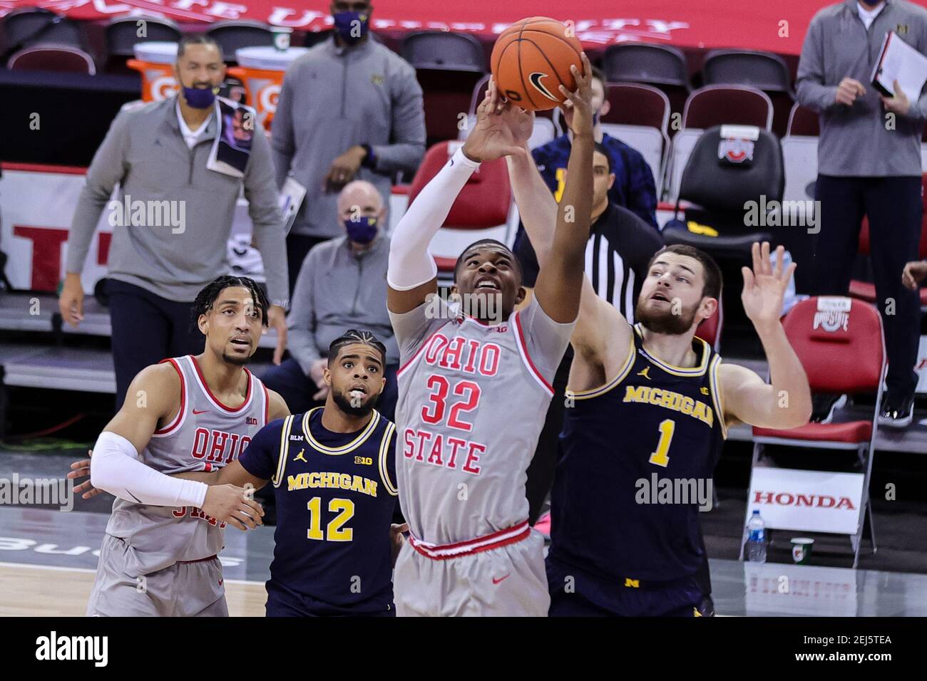 Columbus, Ohio, Stati Uniti. 21 Feb 2021. Ohio state Buckeyes avanti E.J. Liddell (32) afferra un rimbalzo davanti al centro di Michigan Wolverines Hunter Dickinson (1) nel gioco tra i Michigan Wolverines e l'Ohio state Buckeyes a Value City Arena, Columbus, Ohio. Credit: Scott Stuart/ZUMA Wire/Alamy Live News Foto Stock