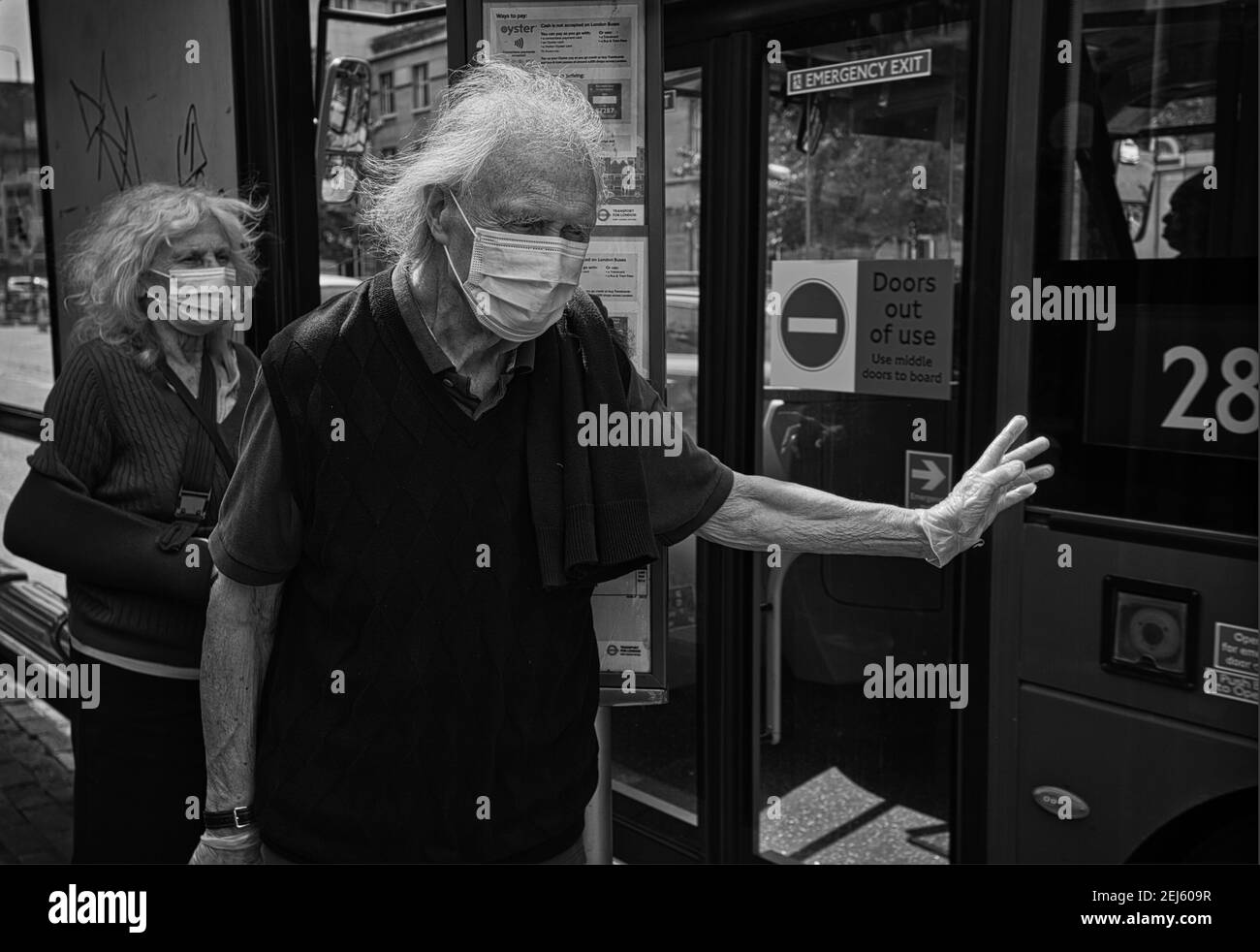 GRAN BRETAGNA / Inghilterra / Londra / UNA coppia più anziana indossando maschere aspetta un autobus a Londra, Inghilterra, il 13 maggio 2020. Foto Stock