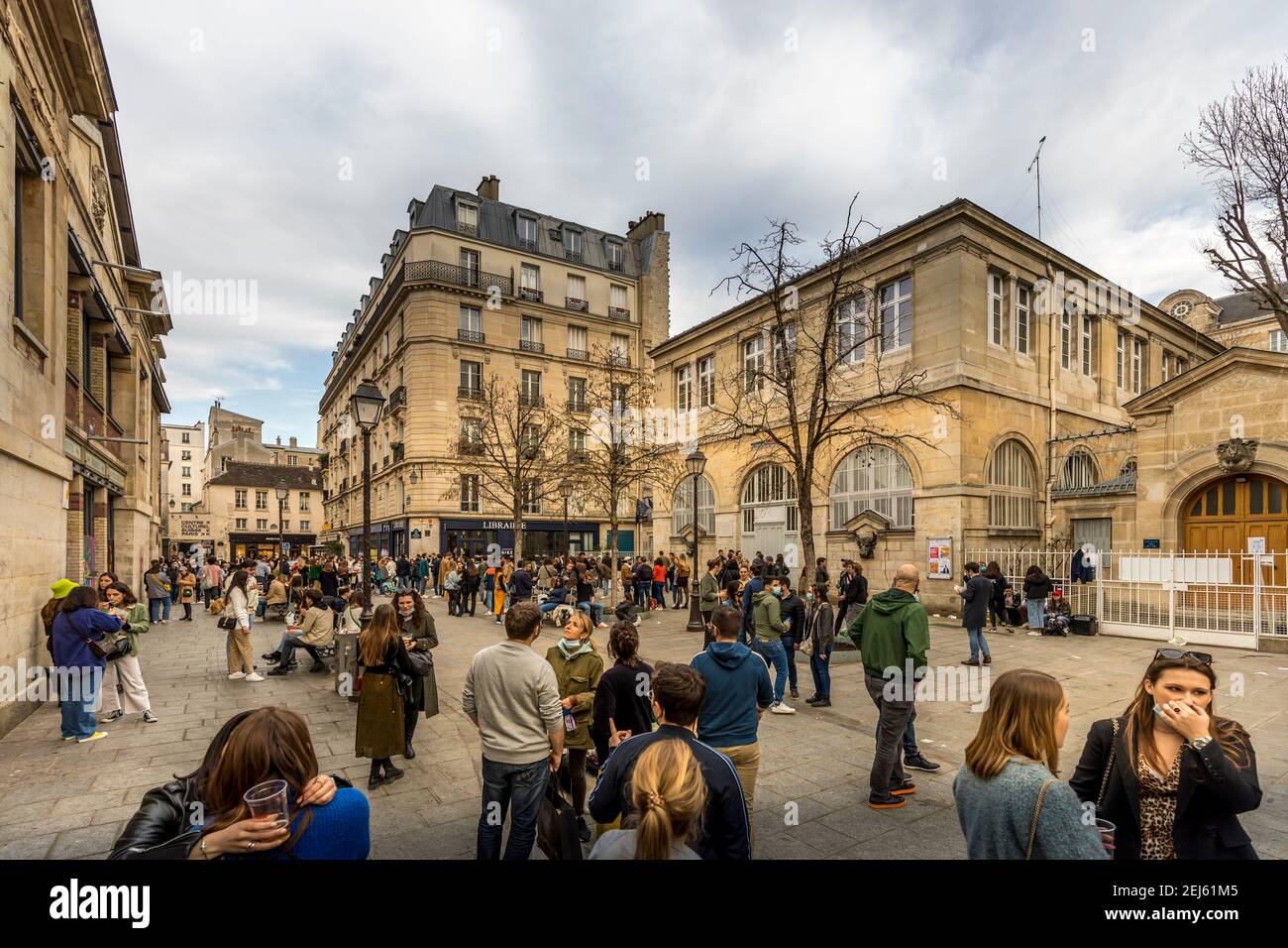 Parigi, Francia - 21 febbraio 2021: Persone che si rilassano sui prati verdi della famosa Place des Vosges - la più antica piazza pianificata di Parigi, durante la covid-19 pandemi Foto Stock