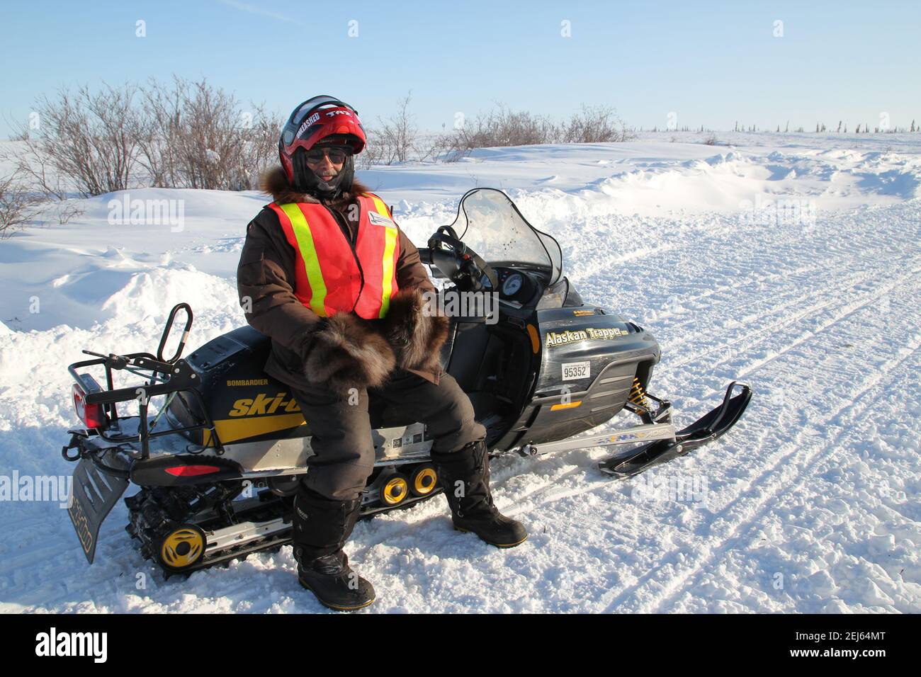 Monitoraggio della fauna selvatica maschile indigena in motoslitta durante la costruzione invernale dell'autostrada Inuvik-Tuktoyaktuk, territori del Nord-Ovest, Artico del Canada. Foto Stock