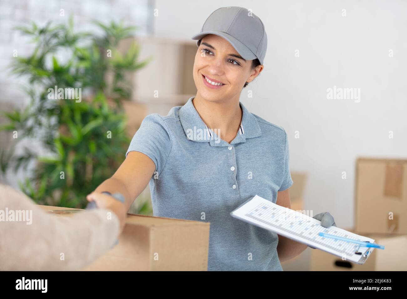 allegra consegna donna scuotendo la mano del cliente Foto Stock