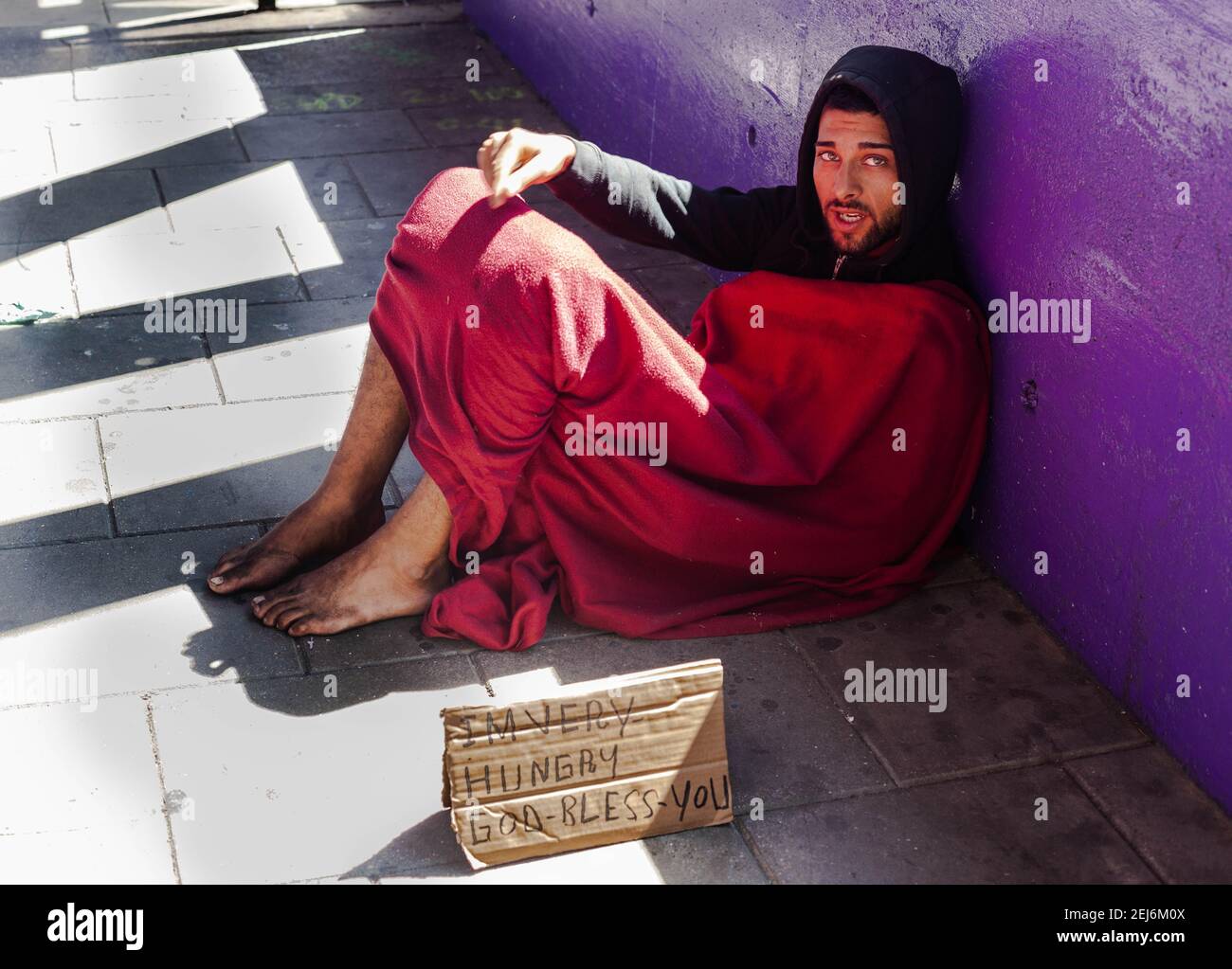 Un giovane senza tetto che chiede denaro su un marciapiede, Londra, Inghilterra, Regno Unito. Foto Stock