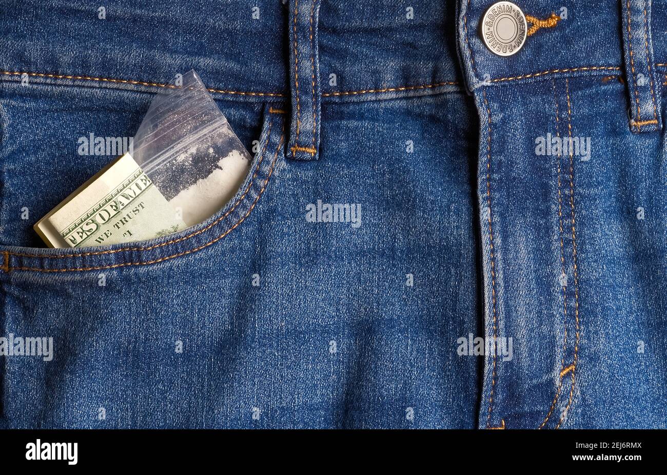 dollari sminuzzati e una borsa di droga in tasca jeans. Primo piano, nessuna faccia Foto Stock