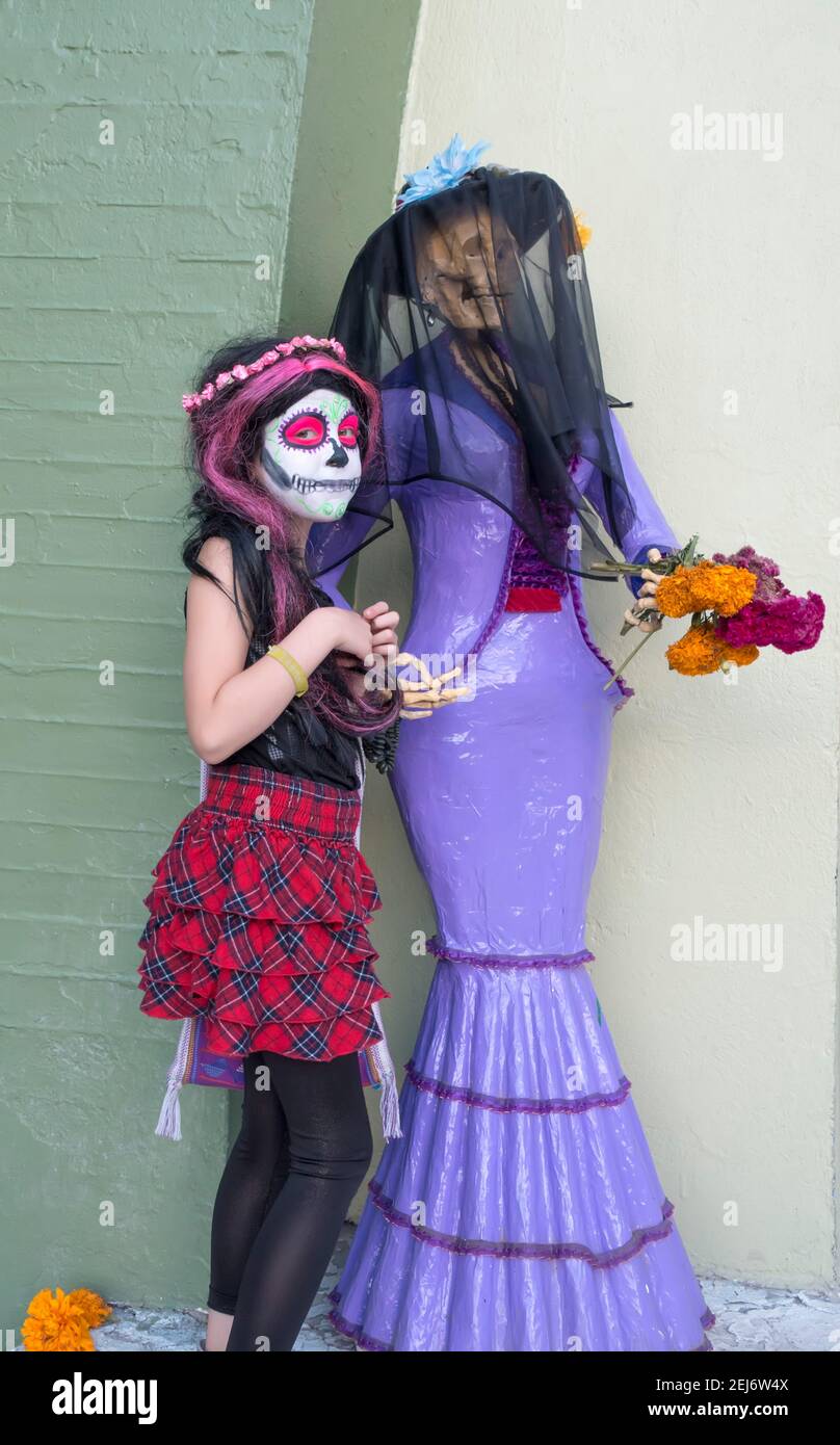 Giovane ragazza con viso dipinto e manichino scheletro il giorno Del Messico morto Foto Stock