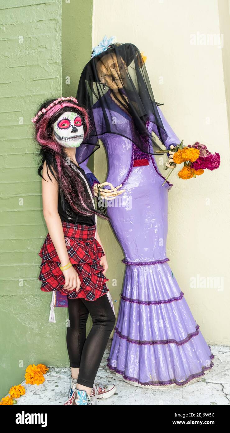 Giovane ragazza con viso dipinto e manichino scheletro il giorno Del Messico morto Foto Stock