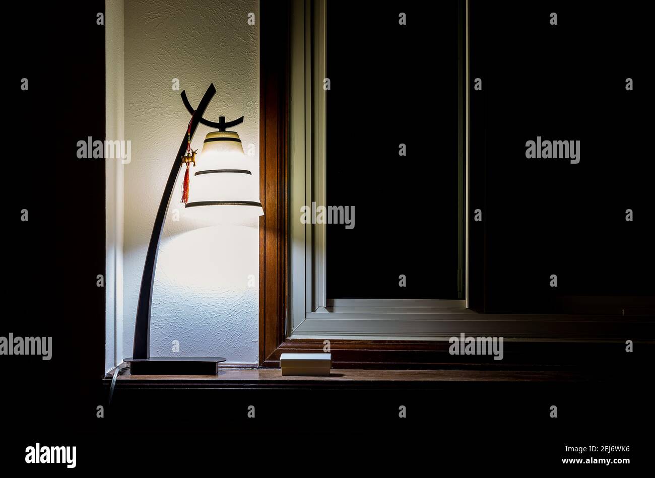 Luce interna calda e vintage vicino alla finestra scura Foto Stock