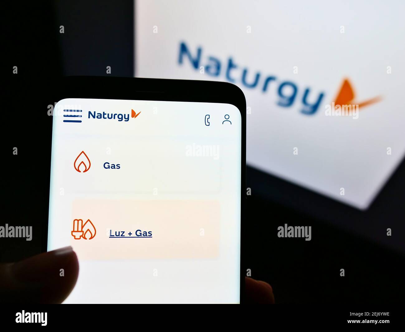 Persona che detiene il telefono cellulare con il sito web della società energetica spagnola Naturgy Energy Group SA sullo schermo con il logo. Messa a fuoco sulla parte centrale superiore del display del telefono. Foto Stock