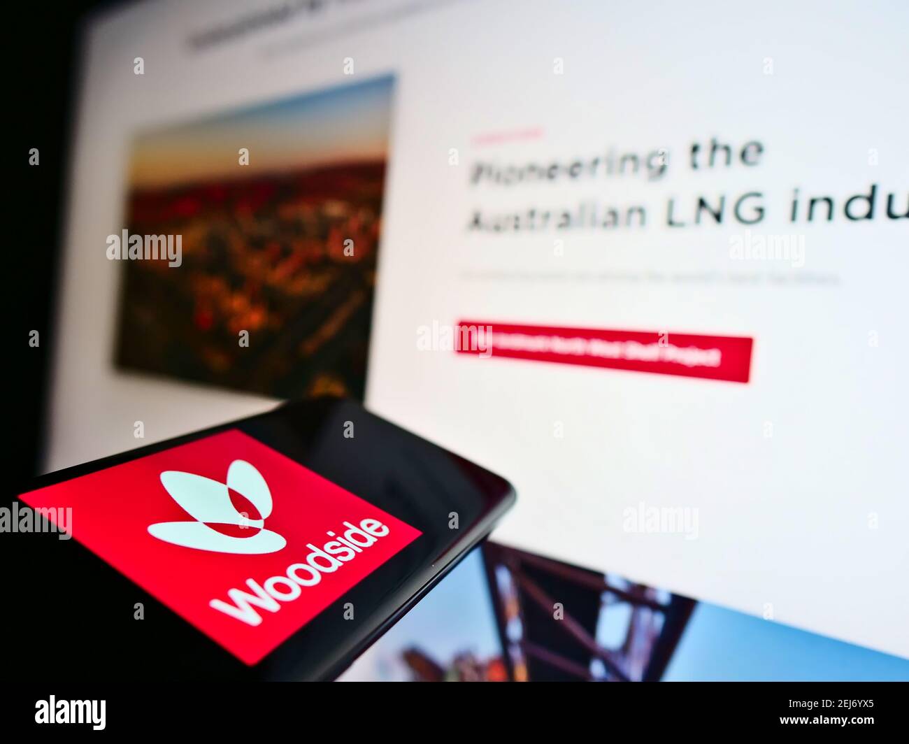 Telefono cellulare con logo aziendale della società petrolifera australiana Woodside Petroleum Limited sullo schermo di fronte al sito web. Mettere a fuoco il centro del display del telefono. Foto Stock