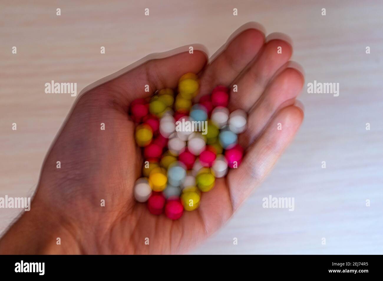 Visione nel diabete mellito. La visione blurry del diabetico prende l'immagine dei lollipops dolci nel palmo della vostra mano. Foto Stock