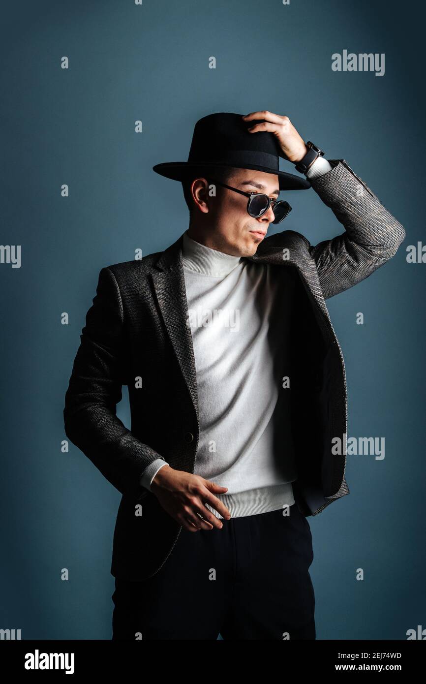Uomo Essentrico in giacca, occhiali da sole e cappello classico su  sfumature di grigio Foto stock - Alamy