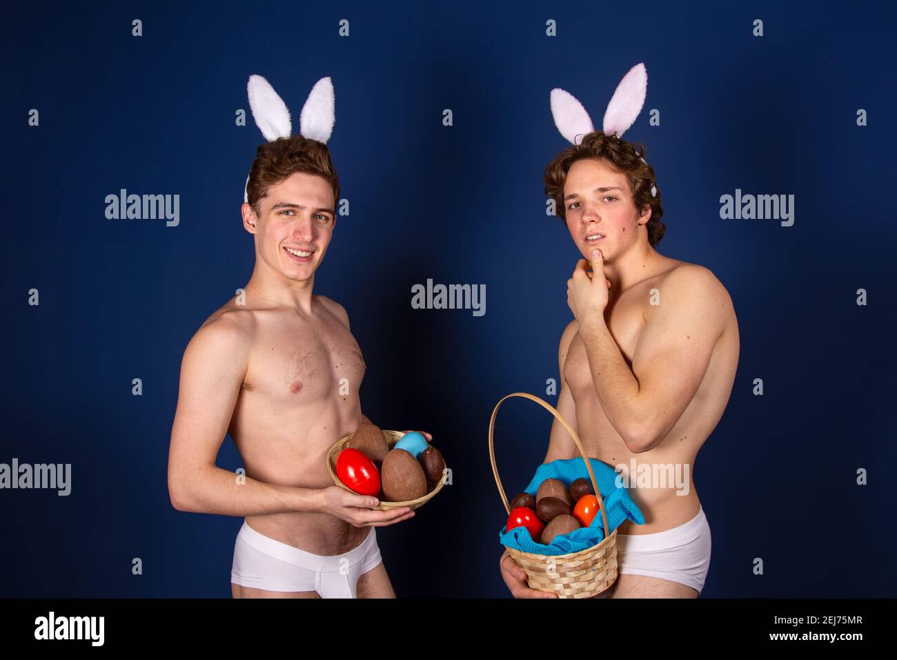 Vacanze e fine settimana. Giovane coppia attraente per Pasqua in costumi bunny. Sfondo bianco. Foto Stock