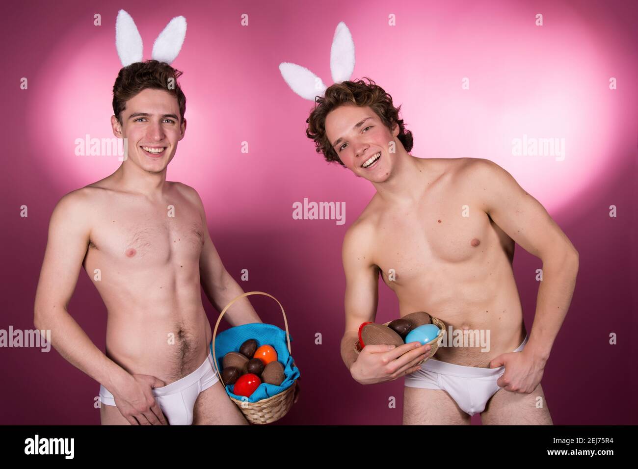 Vacanze e fine settimana. Giovane coppia attraente per Pasqua in costumi bunny. Sfondo bianco. Foto Stock