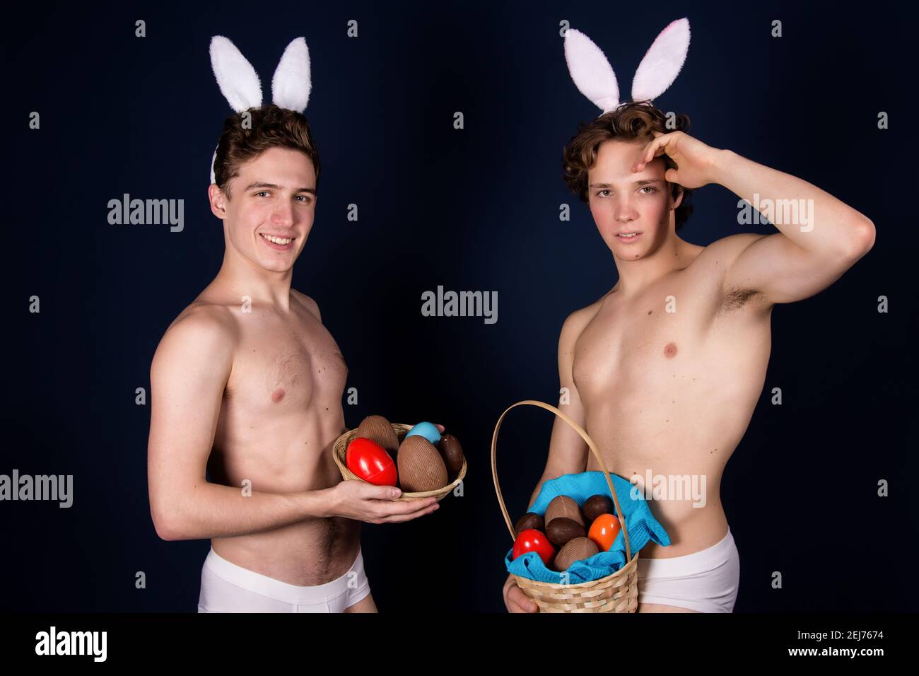 Vacanze e fine settimana. Giovane coppia attraente per Pasqua in costumi bunny. Sfondo bianco. Foto Stock