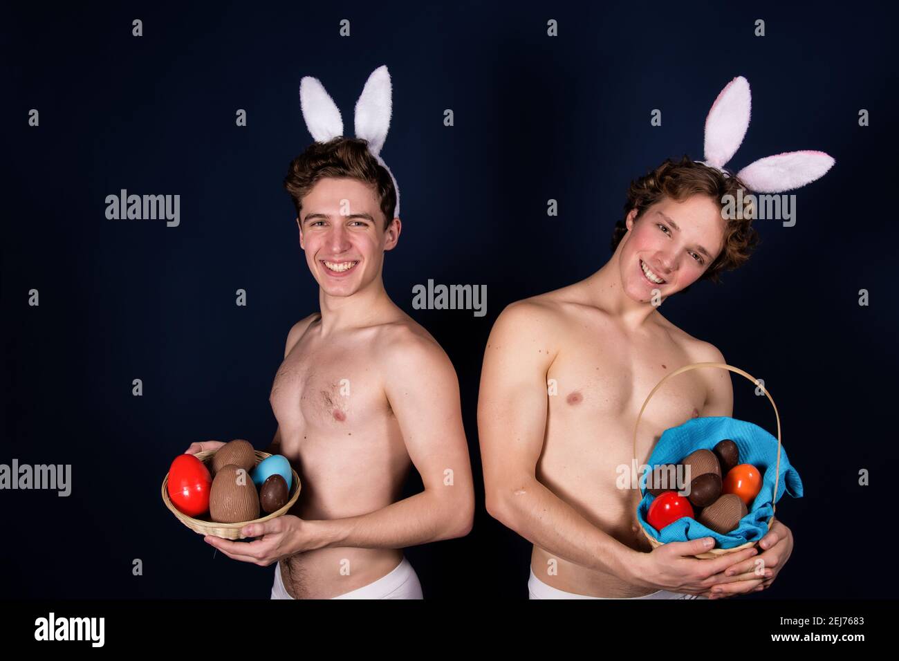 Vacanze e fine settimana. Giovane coppia attraente per Pasqua in costumi bunny. Sfondo bianco. Foto Stock