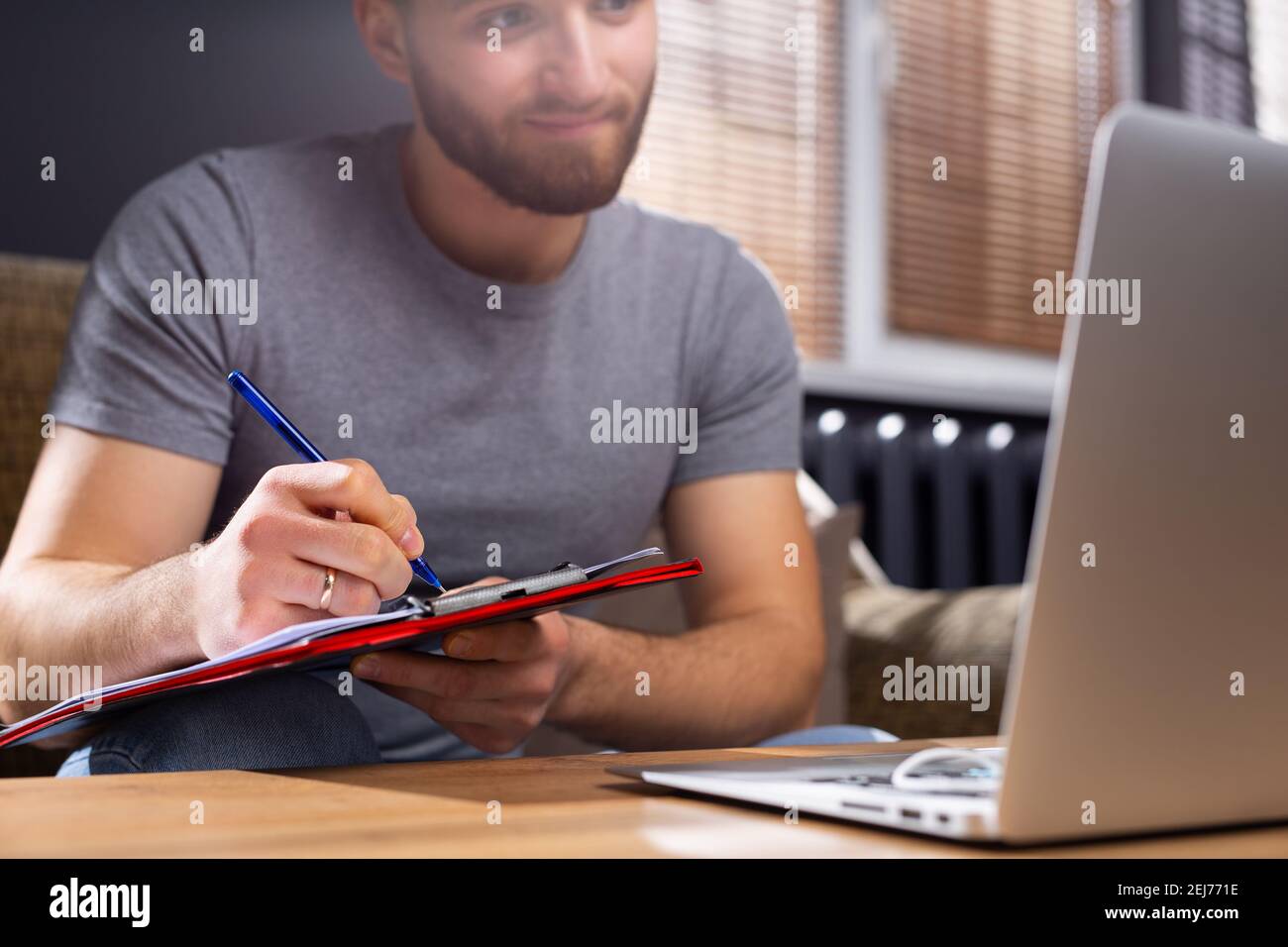 Foto ritagliata di un giovane studente che studia online di fronte al computer portatile di casa. Il concetto di apprendimento durante una pandemia e la massima responsabilità su Foto Stock