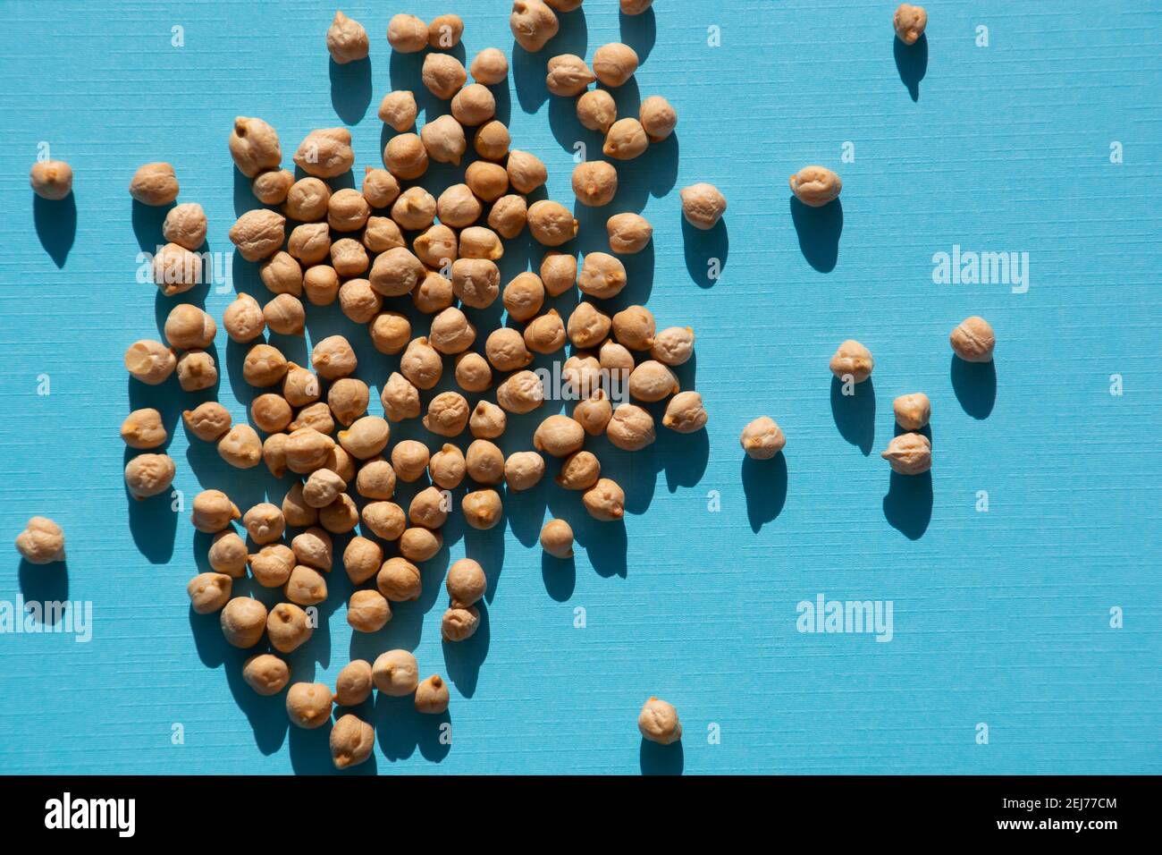 piccoli grani grezzi di ceci fagioli o garbanzo sopra sfondo azzurro chiaro Foto Stock