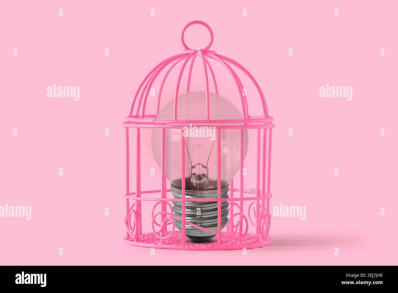 Lampadina in gabbia di uccello rosa su sfondo rosa - Concetto di mente e libertà della donna Foto Stock