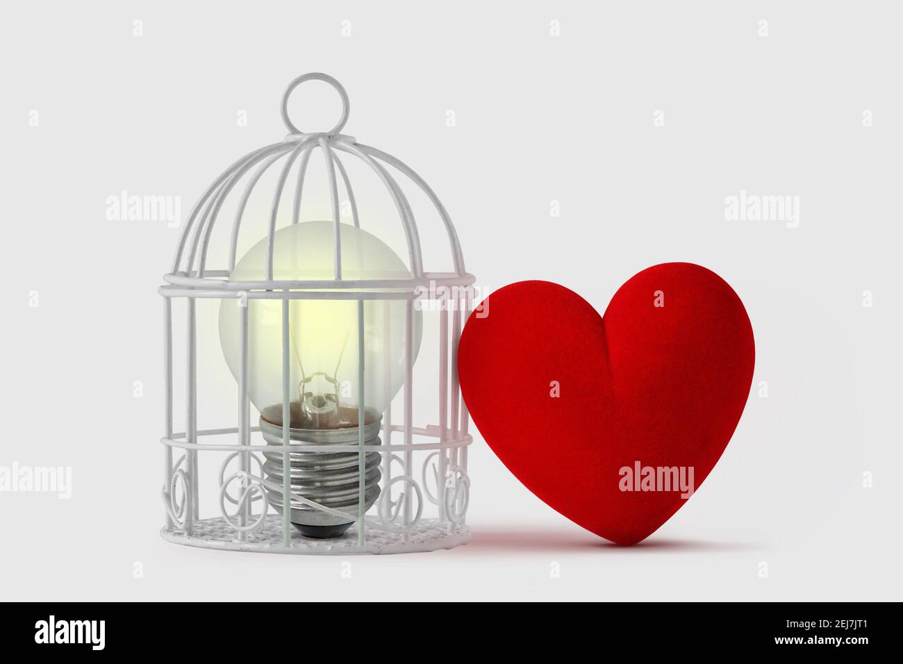 Lampadina in gabbia di uccello con cuore libero - mente e concetto di cuore Foto Stock