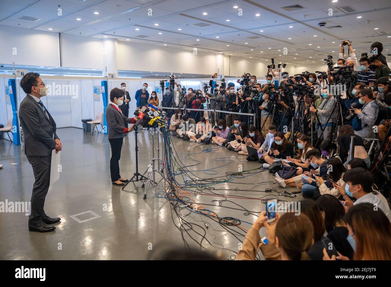 Carrie Lam (L2), Hong Kong Chief Executive parla ai media del Community Vaccination Center presso la biblioteca centrale di Hong Kong dopo aver ricevuto la vaccinazione COVID-19.Hong Kong Chief Executive Carrie Lam e i membri del suo gabinetto ricevono la prima dose del vaccino COVID-19 al fine di aumentare la fiducia del pubblico Al vaccino come programma di vaccinazione per il pubblico inizierà il 26 febbraio. Foto Stock