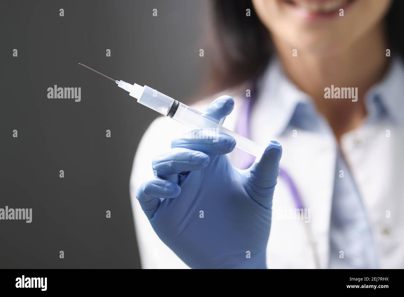 I medici mano nel guanto di gomma che tiene la siringa con il closeup del medicinale Foto Stock