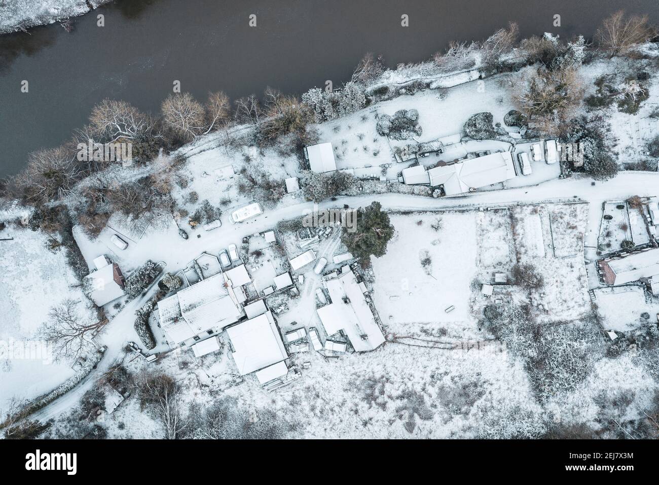 Vista aerea dall'alto sulle rive del fiume spolverate di neve. L'ampia vista panoramica cattura le rive e gli edifici del fiume Severn. Foto Stock