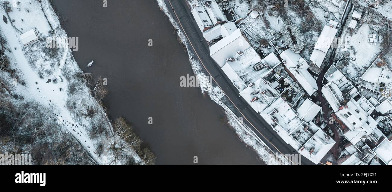 Vista aerea dall'alto sul centro storico di Ironbridge. L'ampia vista panoramica cattura le rive del fiume e gli edifici polverosi di neve. Foto Stock