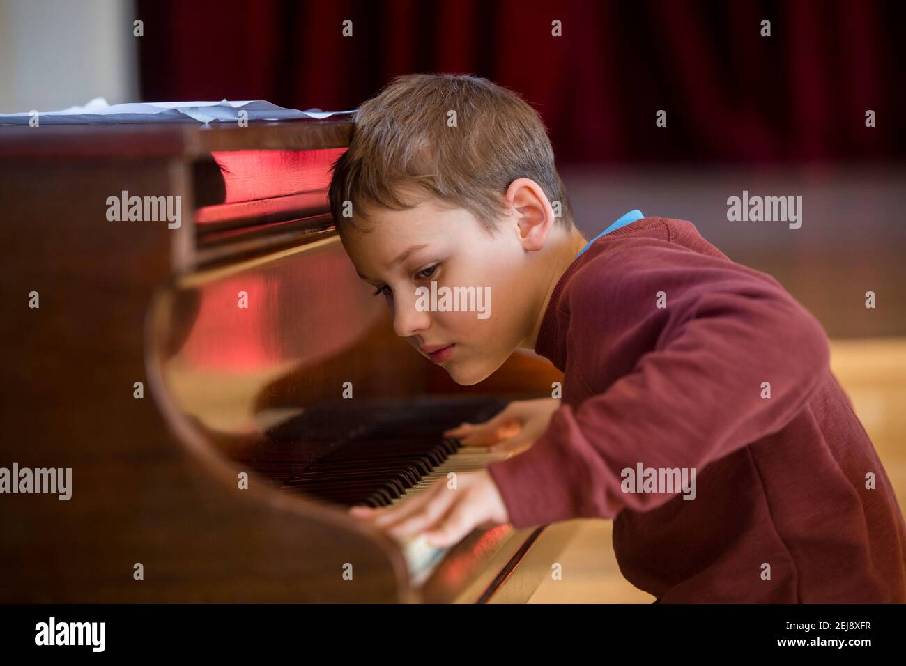 Bambino che suona il pianoforte durante la lezione e l'evento. Concetto di ritorno a scuola per i bambini Foto Stock