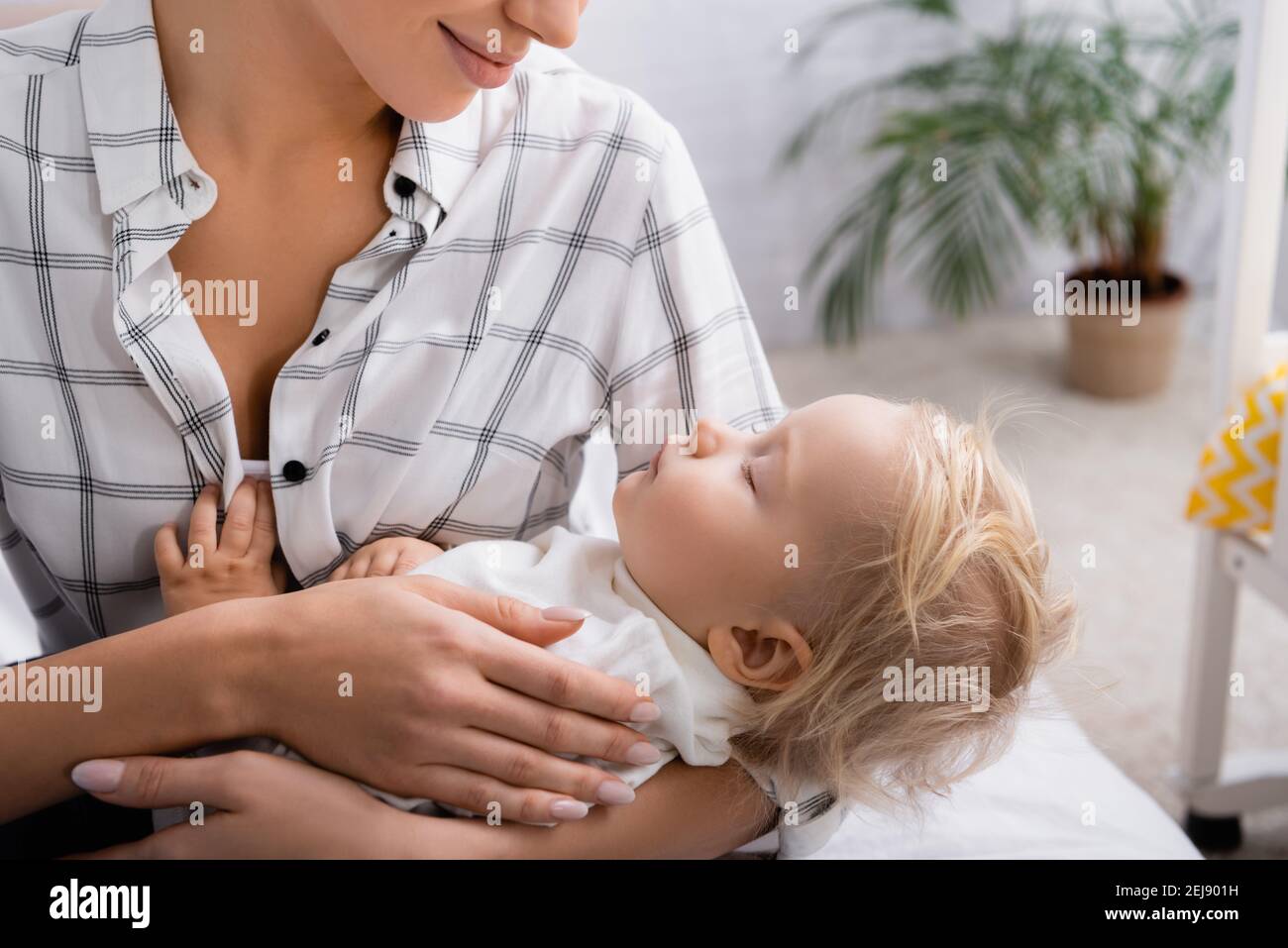 giovane madre sorridente lulling piccolo bambino a casa Foto Stock