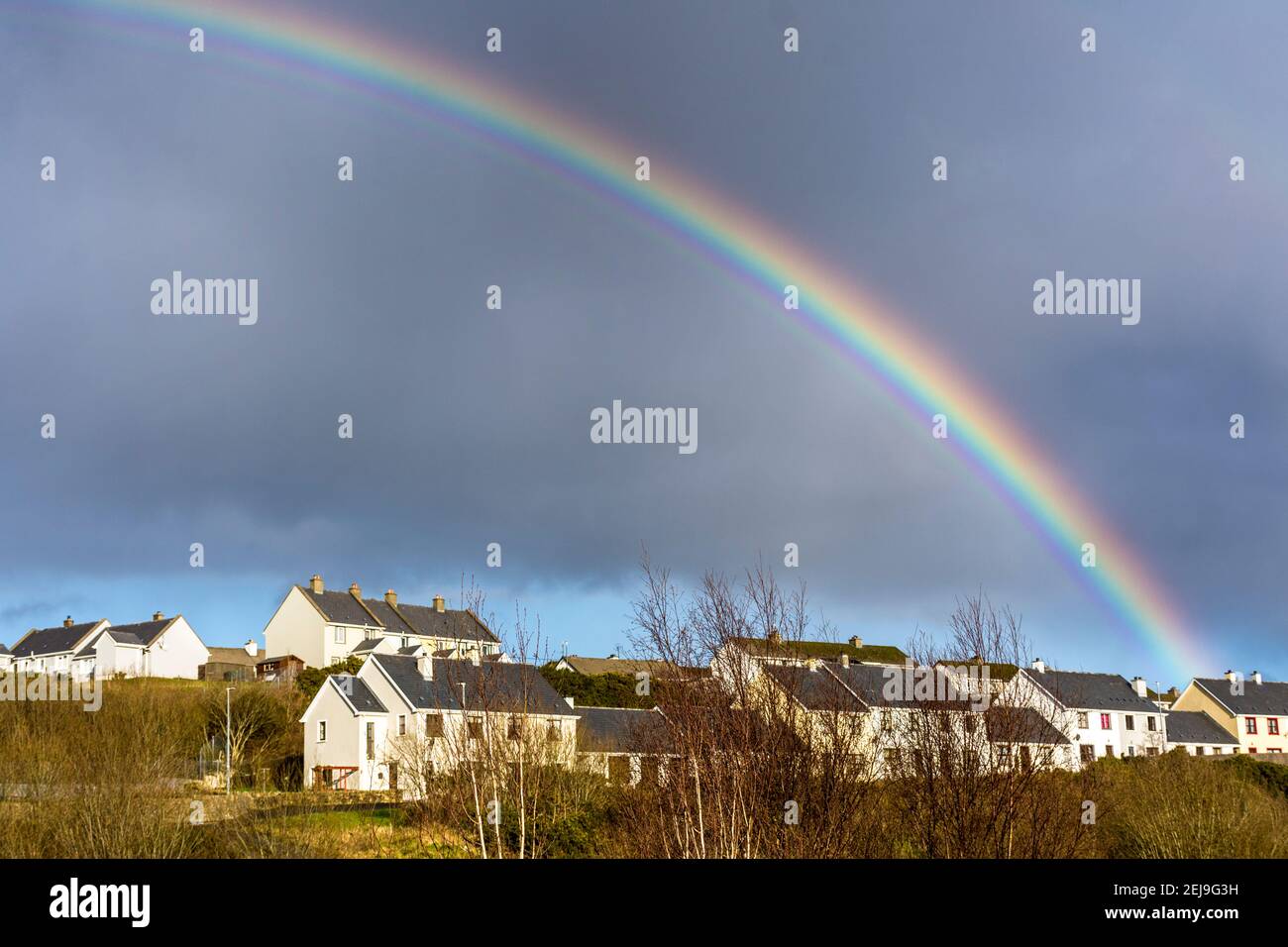 Un arcobaleno appare su alloggi sociali, case del consiglio, terrazza in Ardara, Contea di Donegal, Irlanda Foto Stock